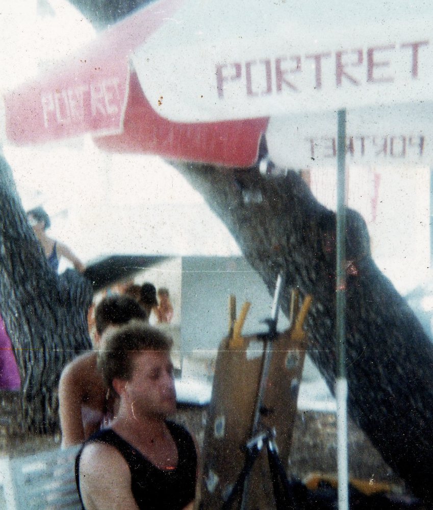 Goran Goda at his harbor portrait stand beneath red and white PORTRET umbrellas, Brela, 1986
